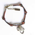 Black, brown and bronze leather bracelet with Africa map and dove emblems.